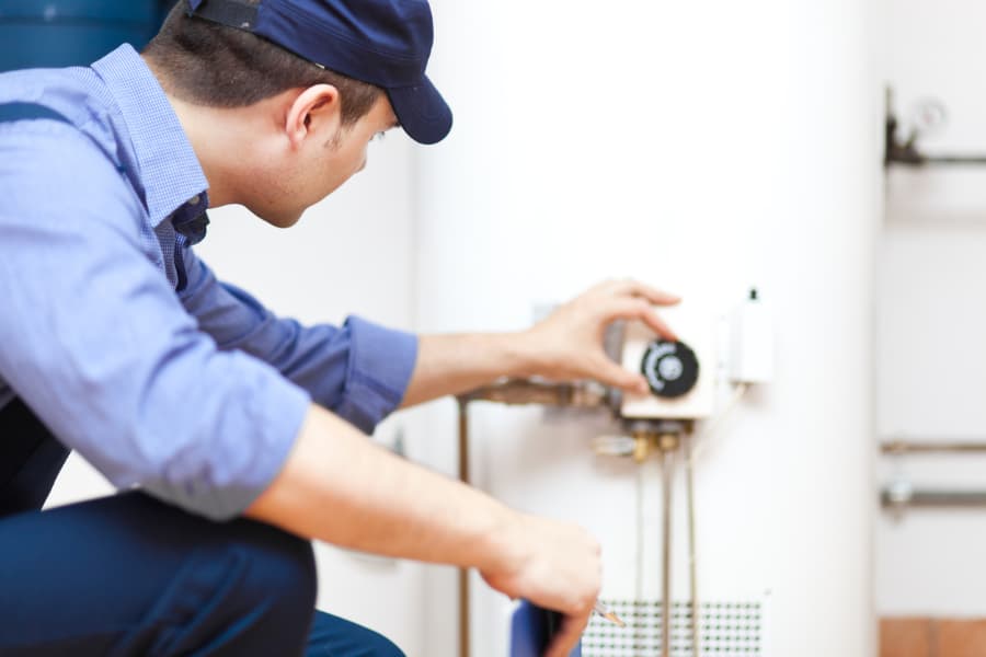 Technician checks the settings on a hot water heater