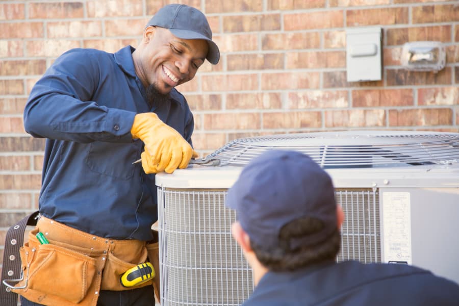 Air conditioner technicians perform spring AC service and maintenance  