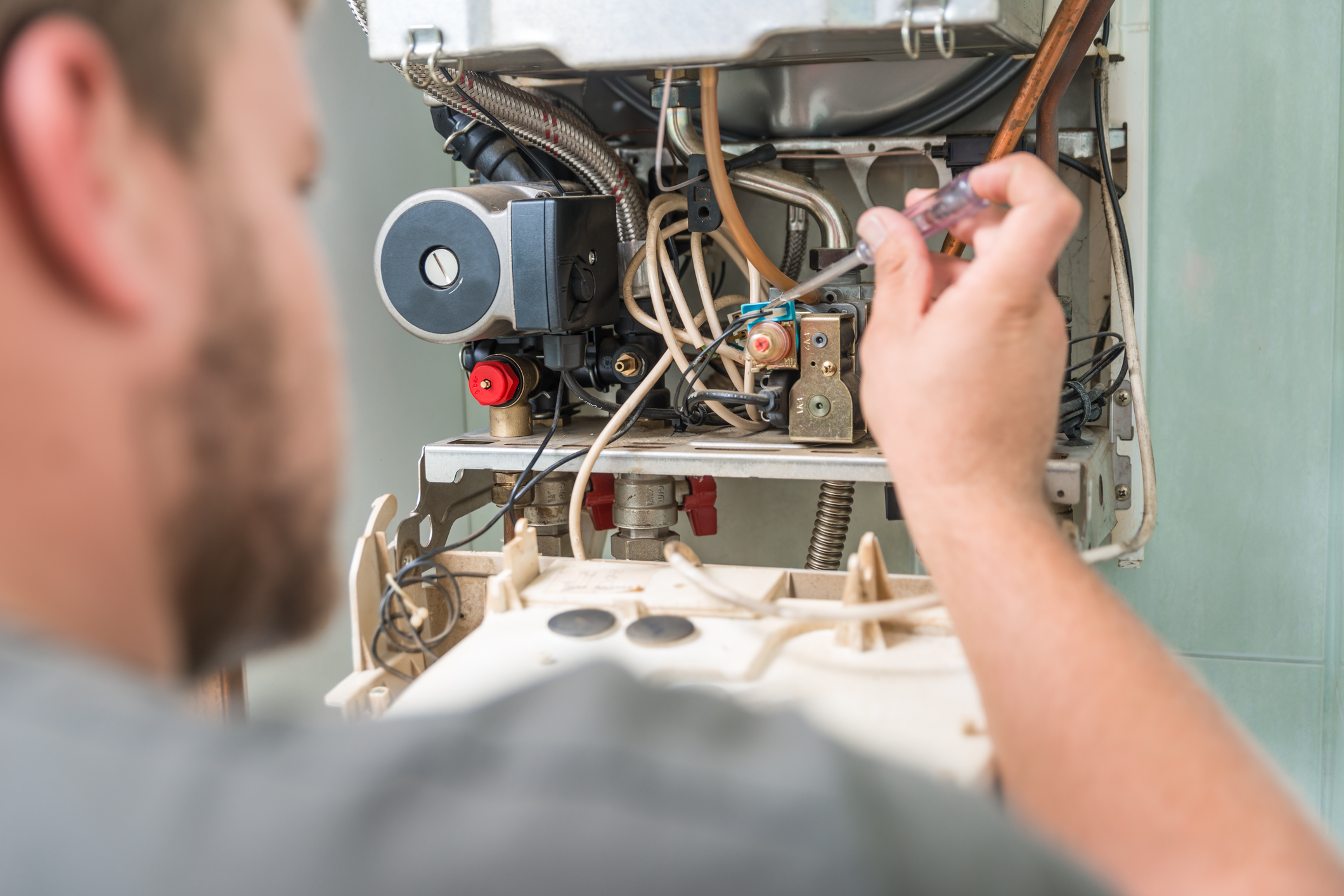 Technician working on open boiler unit