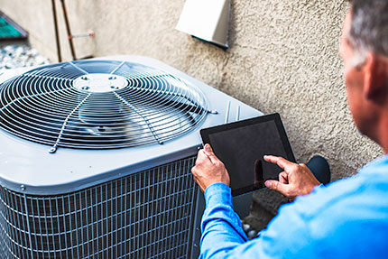 Man With Tablet Near AC Unit