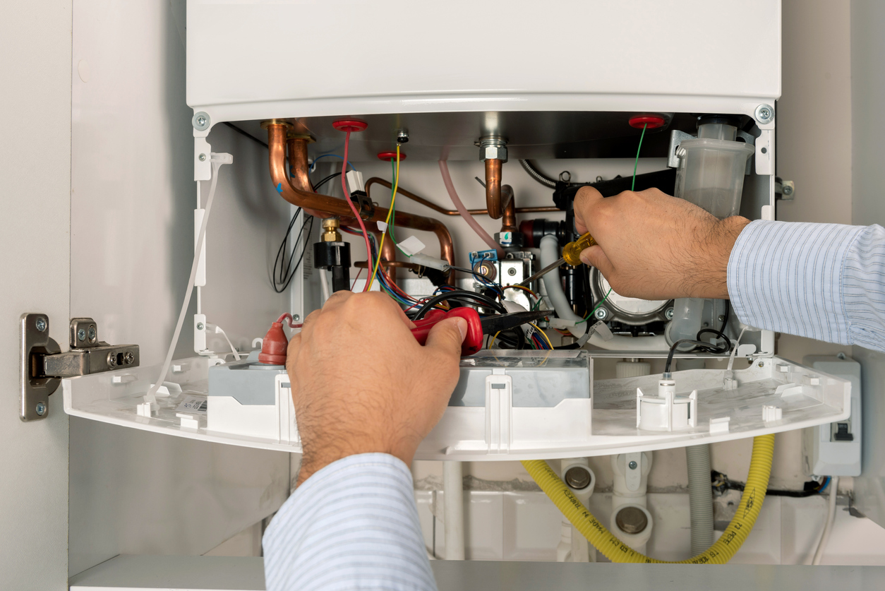 Technician performing maintenance on boiler